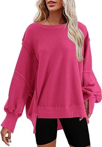 Detail van perzikroze oversized sweatshirt met zijsplit en decoratieve onafgewerkte naden
