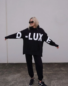 Detail of black D-LUXE letter print on oversized hoodie and matching joggers set