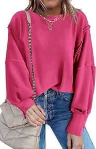 Detail van roze oversized sweatshirt met zichtbare naden en geribbelde manchetten