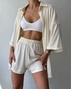 Detail of white three-piece ribbed shorts set showing vertical crepe texture and fit