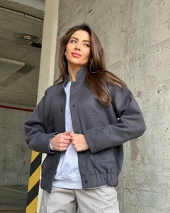 Detail view of charcoal grey workwear jacket with snap buttons and large utility pockets
