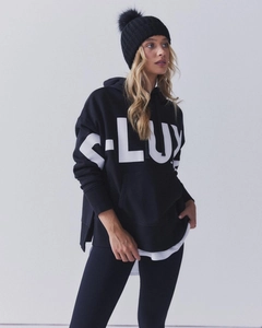 Detail of the oversized black hoodie featuring a bold white S-LUX letter print on chest