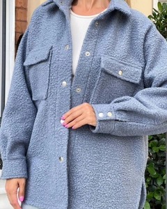 Detail of blue teddy fleece shirt jacket featuring soft texture and silver buttons
