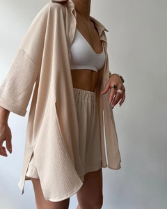 Detail of beige split mid-sleeve shirt and high waist shorts two-piece set for women