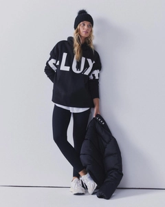 Detail showing high-contrast white LUX lettering on a black casual winter hoodie