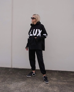Detail of black oversized hoodie featuring white LUX lettering and thumbhole cuffs design