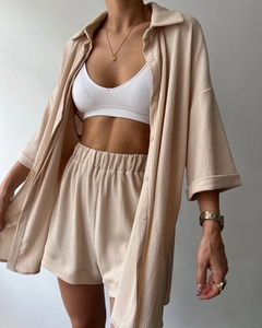 Detail of apricot three-piece set showing textured shirt, shorts and white ribbed bra