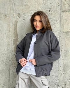 Detail of dark grey wool-like baseball jacket with snap buttons and drop shoulders