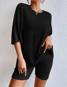 Detail of black ribbed knit lounge set featuring a loose top and high-waist cycling shorts