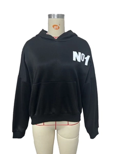 Detalle de sudadera negra con capucha con logo Nº1 blanco impreso y bolsillo canguro
