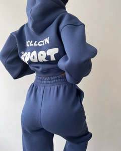 Vue détaillée du survêtement bleu marine avec imprimé blanc CLLCTN SPORT au dos