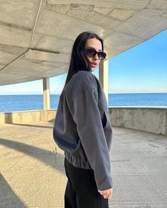 Detail of dark grey drop shoulder jacket with elastic cuffs and convenient side pockets