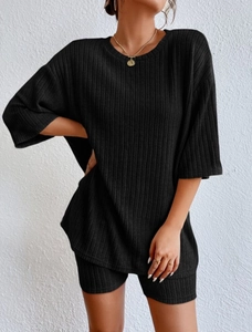 Detail of black ribbed knit fabric showing the texture of the round neck two-piece set