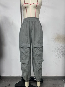 Detail of grey cargo pants showing high elastic waist and multi-pocket design on the side