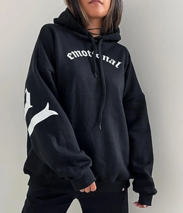 Gros plan détaillé du lettrage gothique blanc 'emotional' sur un sweat à capuche noir large