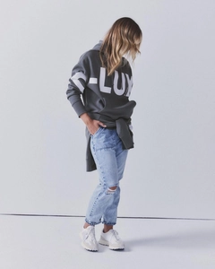 Fashionable dark gray oversized hoodie with white D-LUXE letters and ripped blue jeans