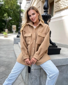 Detail of camel fuzzy shacket showing textured sherpa fabric and large chest pockets