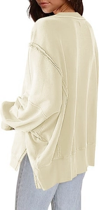 Detail van oversized crème sweatshirt met zichtbare naden en zijsplitten aan de zoom