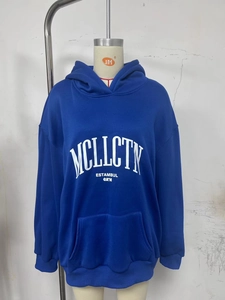 Dettaglio di felpa con cappuccio blu reale con scritte bianche, tasca a marsupio e polsini