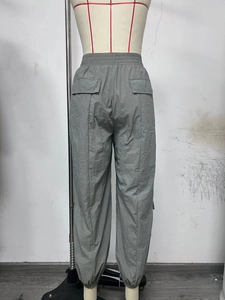Detail view of grey cargo pants featuring elastic waist and back flap pockets for women