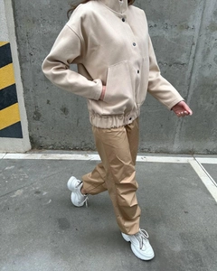 Outdoor street style view of a beige stand-collar jacket paired with khaki trousers