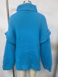 Vue détaillée du pull en maille épaisse bleu Klein avec volants élégants sur les manches