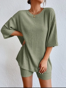 Detailed macro view of sage green ribbed knit fabric on casual two-piece summer shorts set