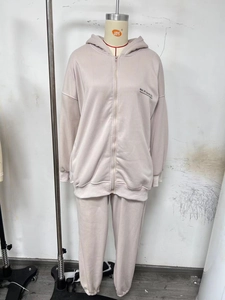Detail of light beige hoodie set with black MAI STUDIOS CO. letter print on the chest