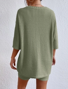 Detail of green ribbed knit two-piece lounge set showing loose fit top and shorts texture
