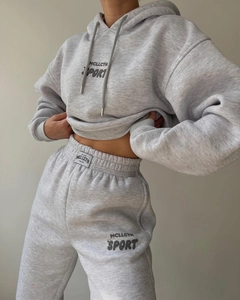 Détail d'un sweat à capuche gris doublé polaire et d'un jogging assorti au style sportif