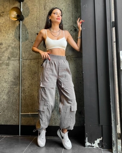 Detail view of high-waist loose cargo pants with multiple pockets and drawstring hem