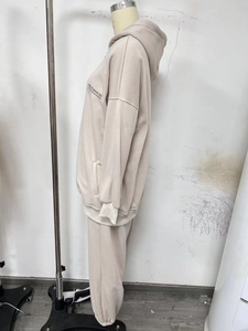 Side view of beige fleece tracksuit featuring MAI STUDIOS CO. print on the hoodie