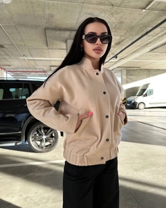 Close-up of beige stand-collar jacket with single-breasted metal buttons and large pockets