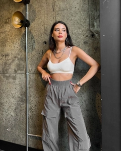 Detail of high-waist cargo pants with large flap pockets and elastic waistband style
