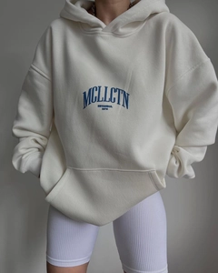 Dettaglio felpa bianca con cappuccio oversize con stampa blu e tasca a marsupio