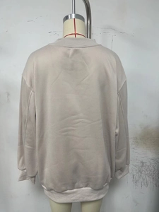 Rear view of a light beige oversized sweatshirt featuring drop shoulder and ribbed cuffs