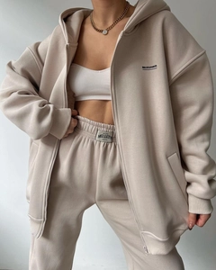 Close-up of beige fleece hoodie set featuring MAI STUDIOS CO. text and premium fabric texture