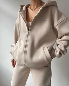 Detail of Mai Studios Co. beige fleece hoodie set showing logo print and soft fabric texture