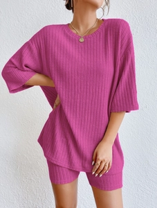 Detailed macro view of the ribbed knit fabric and stitching on the pink two-piece set