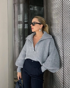 Detailansicht grauer Rippstrickpullover mit V-Ausschnitt, Kragen und modischen Laternenärmeln