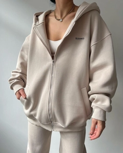 Detail of off-white oversized zip-up hoodie with MAI STUDIOS CO. logo and ribbed cuffs