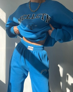 Detail of blue fleece tracksuit set featuring deer print and white woven waist label