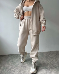 Detail of beige fleece zip-up hoodie set with joggers and white crop top in a macro view