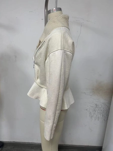 Detail view of cream-colored jacket with faux shearling collar and peplum hem detail