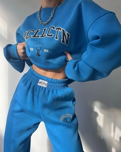 Detail of blue fleece tracksuit with MCLLCTN letter print and graphic deer logo