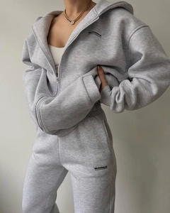 Detail of grey hooded zip-up tracksuit featuring black MAI STUDIOS CO letter print
