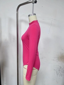 Detail of rose red ribbed fabric and mock neck design on the long sleeve bodysuit