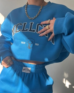 Detail view of the MCLLCTN logo print and thick cotton texture on this navy tracksuit
