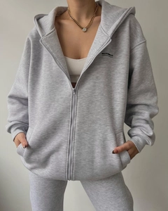 Detail of grey hooded tracksuit with MAI STUDIOS CO print and metal zipper closure