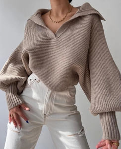 Details des groben Strickpullovers in Khaki mit hohem Kragen und modischen Ballonärmeln
